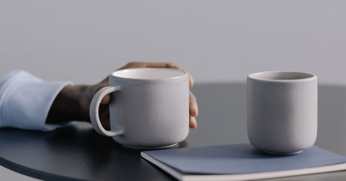 Low side table with a ceramic cup and a closed notebook
