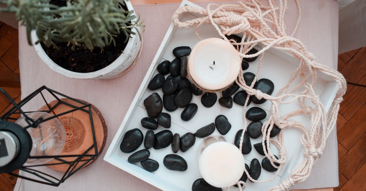 Shelf with an unlit candle and a smooth stone on wood