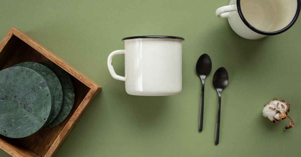 Terracotta ceramic cup next to a wooden spoon